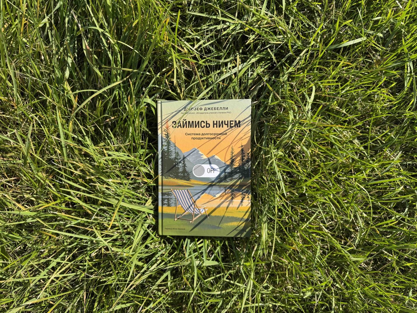 Книга «Займись ничем» Джозефа Джебелли лежит в летней траве